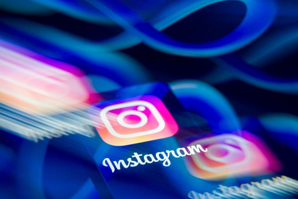 Une social media manager ajuste sa stratégie Your Algorithm Instagram sur smartphone dans un studio créatif