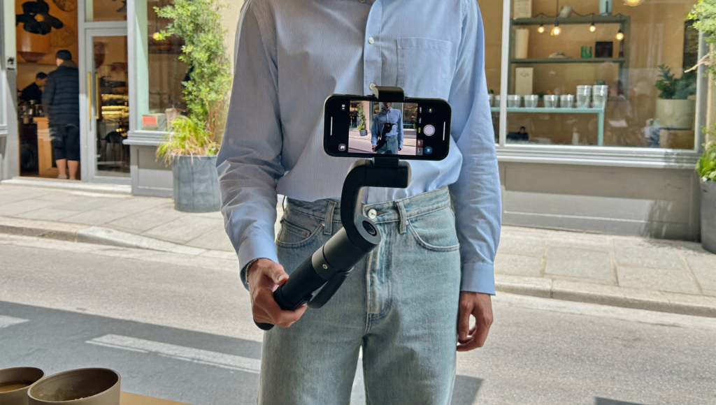 Créateur filmant un commerce local au smartphone pour le TikTok Nearby Feed en centre-ville