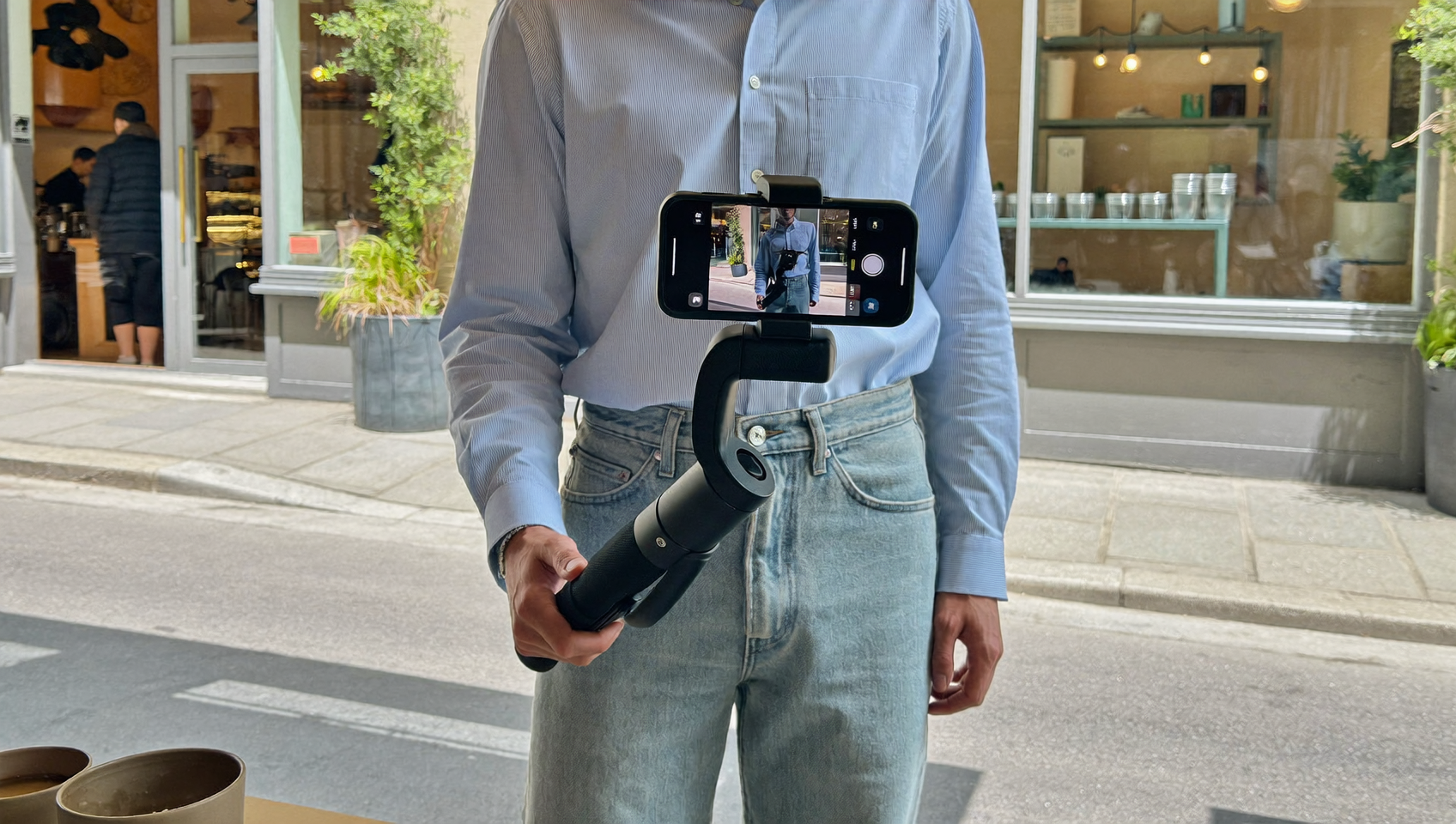 Créateur filmant un commerce local au smartphone pour le TikTok Nearby Feed en centre-ville