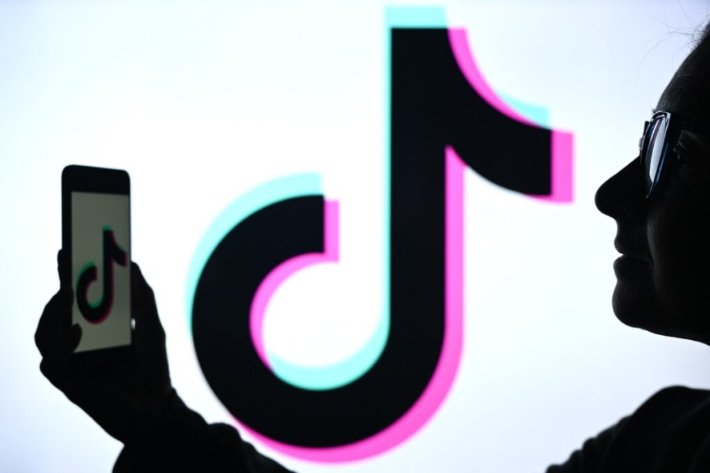 Créateur filmant un commerce local au smartphone pour le TikTok Nearby Feed en centre-ville