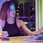 Commerçante qui analyse l'emplacement Threads de ses campagnes publicitaires sur un ordinateur portable derrière son comptoir