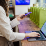 Commerçante qui vérifie les moyens de paiement Shopify sur son smartphone derrière le comptoir de sa boutique