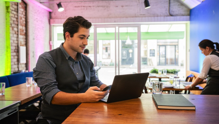 Gérante de restaurant consultant son smartphone au comptoir, illustration de la Connected Apps Platform de Google pour les PME