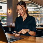 Gérante de restaurant sécurisant son Meta Account avec son empreinte digitale sur smartphone derrière le comptoir