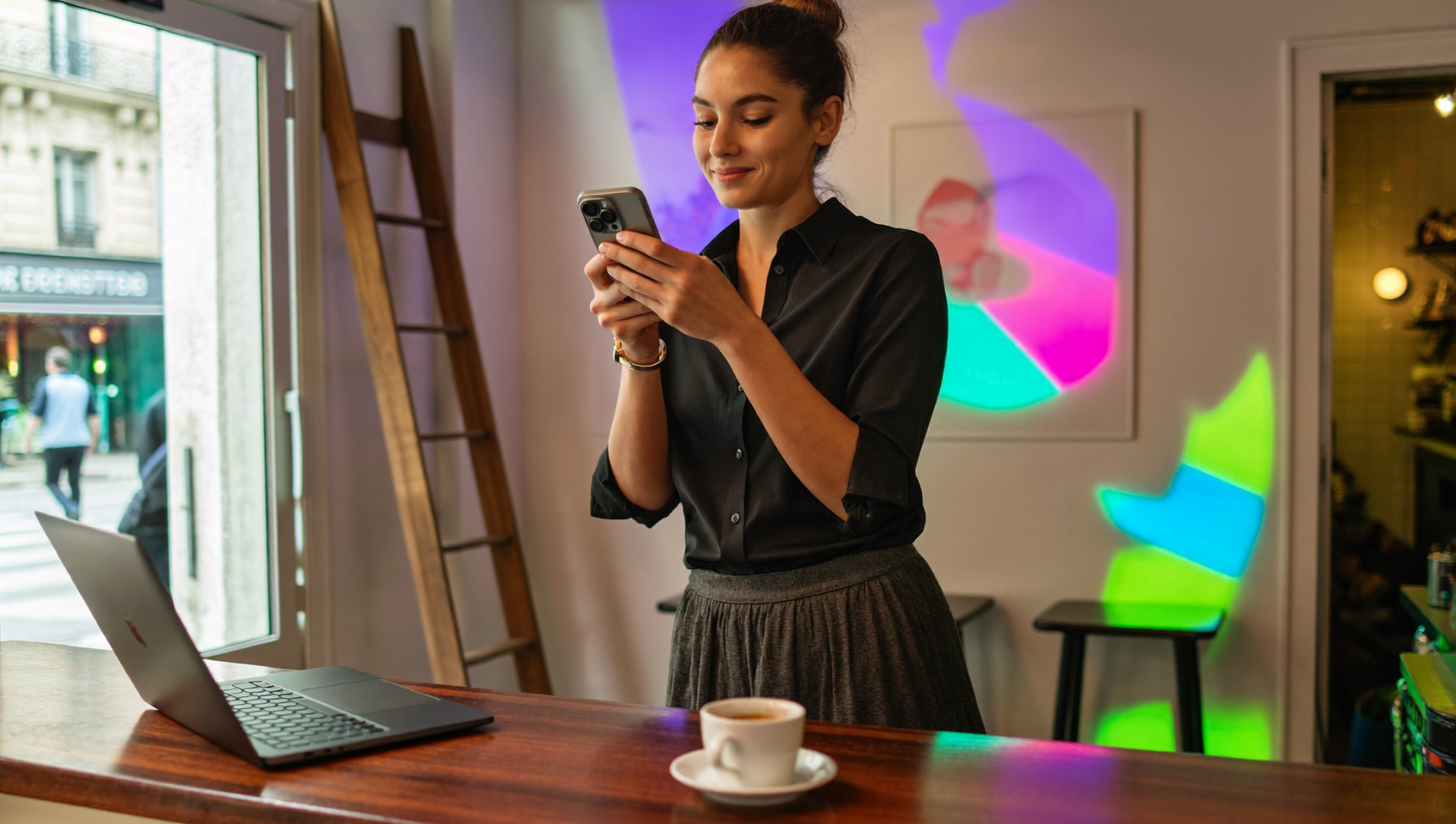 Gérante de restaurant vérifiant sur son smartphone le lien Messenger de sa fiche Google derrière son comptoir
