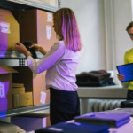 Une commerçante scanne des cartons dans sa réserve pour son inventaire Shopify avant le Black Friday