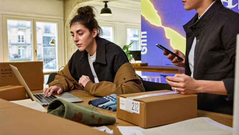 Une e-commerçante vérifie ses fiches produits pour ChatGPT Shopping dans son atelier parisien